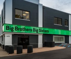 A black building with green stripe.