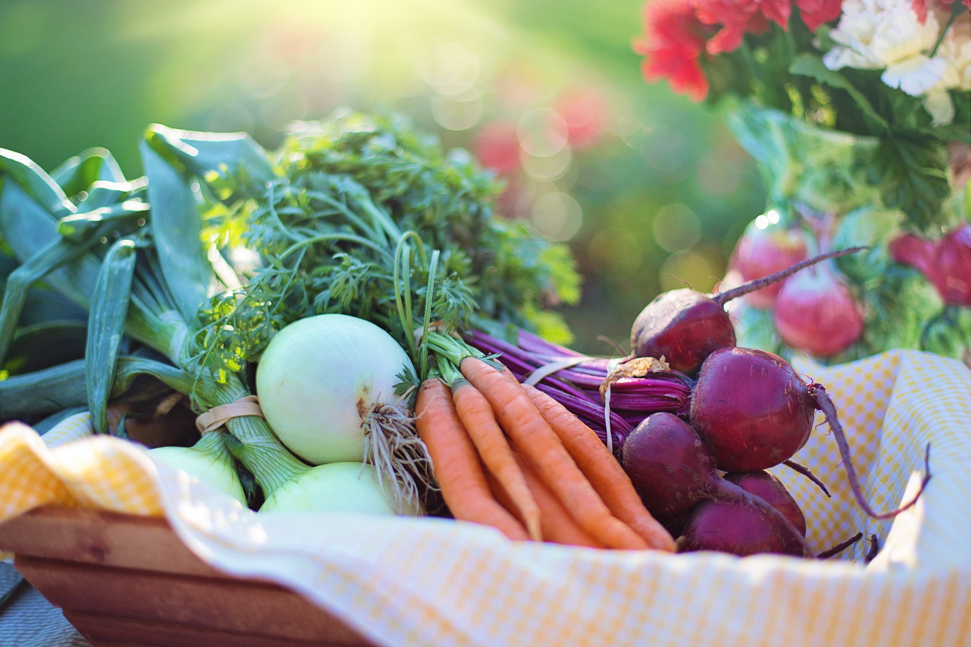 Carrots, onions, and beets in a basket.