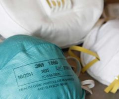 Three N95 respirator masks on a table.
